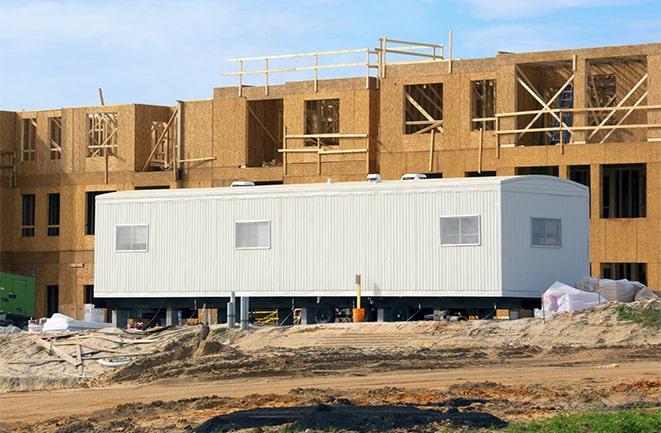 workers studying blueprints in a temporary rental office in Warren